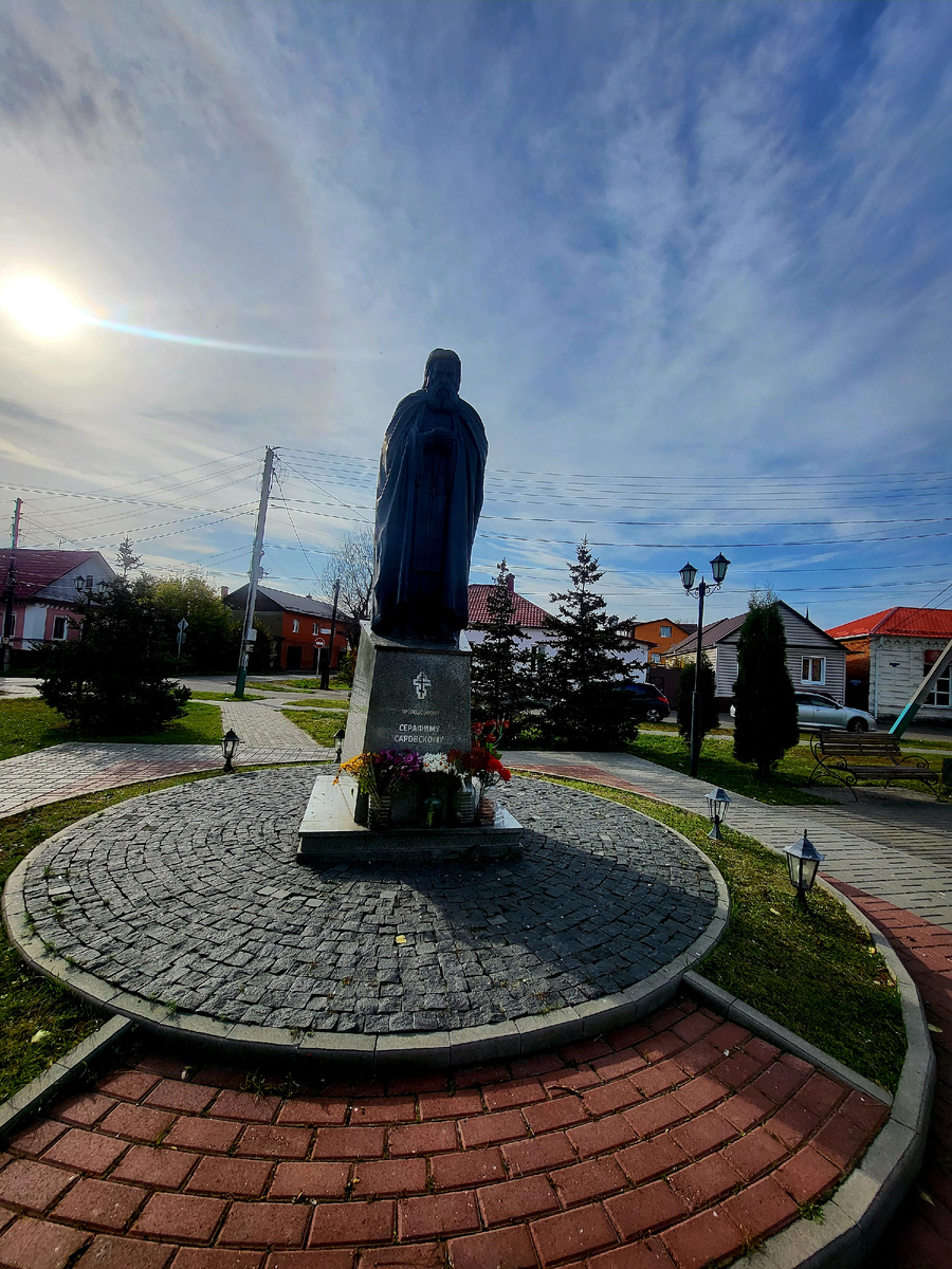 Есть в этом городе место особой, тихой силы. Сквер у Вознесенского монастыря — это не просто зелёный уголок в центре суеты. Это островок умиротворения, где время замедляет свой бег.

И в центре этого спокойствия — он, святой старец Серафим Саровский. Бронзовый памятник, отлитый с такой любовью, что кажется, вот-вот с его ладони слетит птичка, а с губ сорвётся ласковое: «Радость моя, Христос воскресе!».

📿 Серафим Саровский — один из самых почитаемых святых на Руси. Его жизнь — пример безграничной любви, смирения и помощи страждущим. И теперь он здесь, в Мичуринске, с протянутой рукой, словно благословляя каждого, кто проходит мимо.

Присядьте на скамейку в этом сквере. Почувствуйте, как шелест листьев сливается с тишиной, а взгляд старца дарит ощущение мира и защищённости. Это место, где можно передохнуть, подумать о вечном и просто побыть наедине с собой.