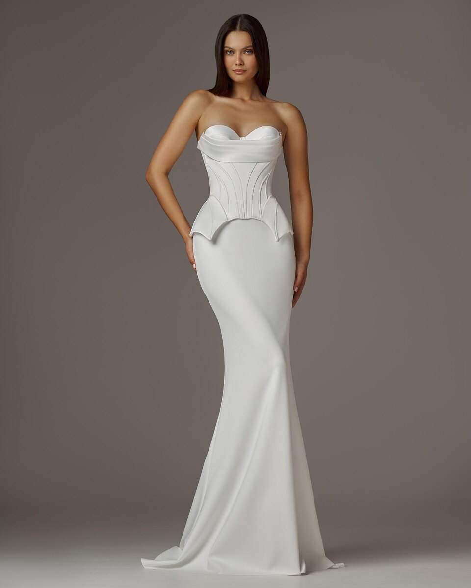 Платье из коллекции CORSET SUITE - это геометричный корсет, красиво формирующий линию бедра, юбка силуэта Рыбка выполнена из атласа и имеет геометричный чёткий силуэт.