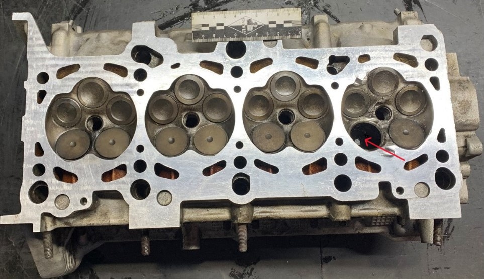 Фото 2. ГБЦ. Вид со стороны плоскости разъема. Посадочное место разрушенного клапана показано стрелкой.