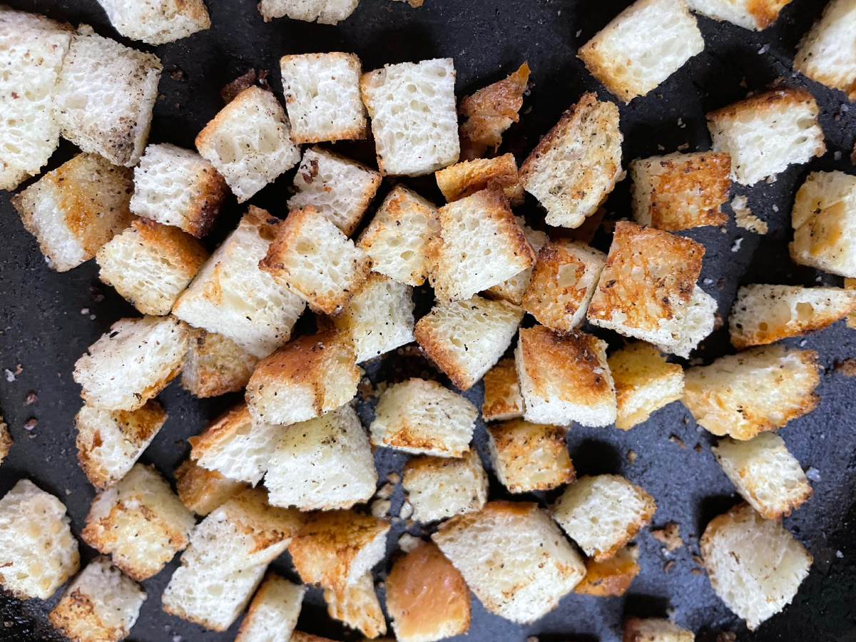 Пожарила сухарики. Для этого нарезала булочку на квадратики, немного намазала маслом и добавила чуть-чуть соли и перца.