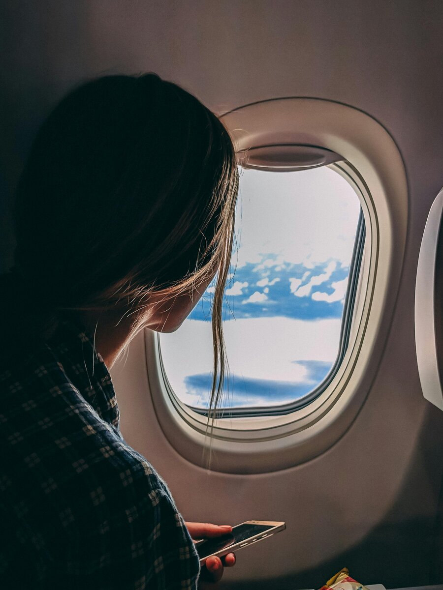 Photo by Jason Toevs: https://www.pexels.com/photo/person-holding-smartphone-riding-airplane-2033343/