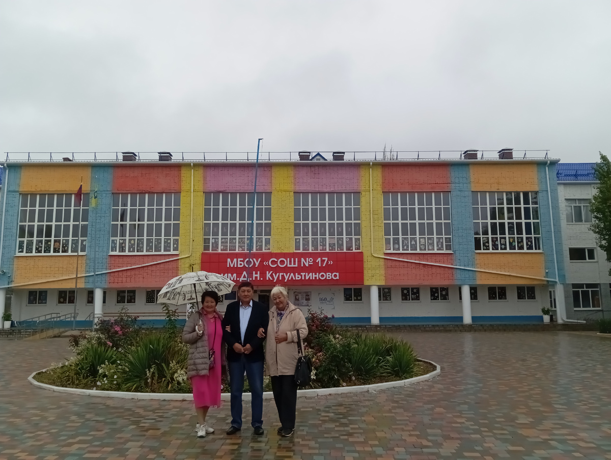 Трое однокашек на фоне школы. 