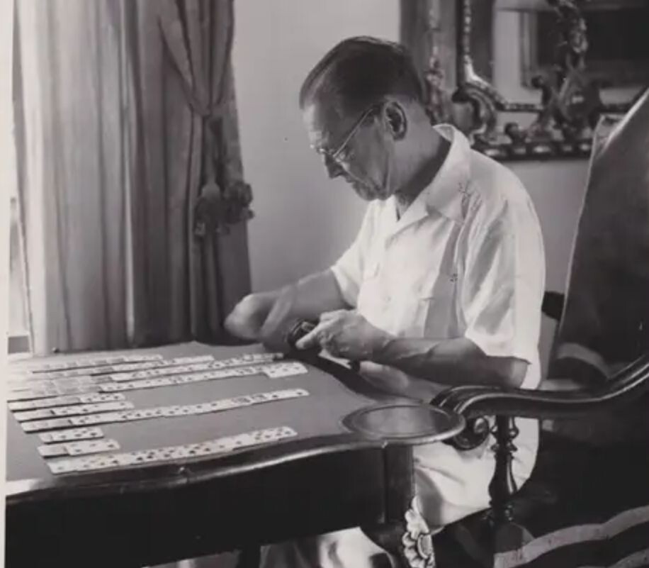 Здесь Моэм запечатлён за игрой в пасьянс (solitaire) за столом в той же вилле La Mauresque в Кап-Ферра, Франция. Фото датируется примерно 1950-ми годами, автор — Ник де Морголи.