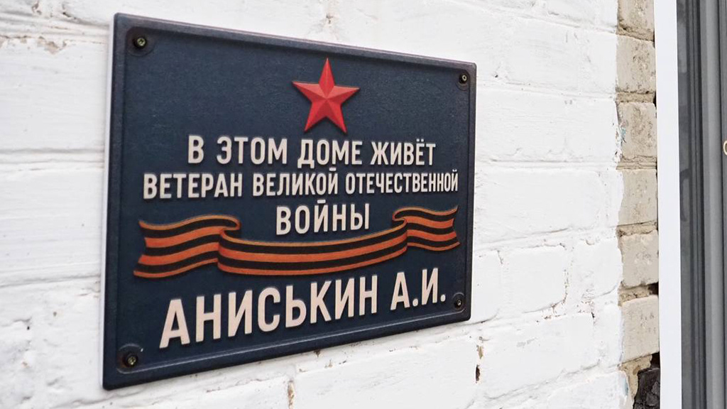 Именная табличка на фасаде дома ветерана