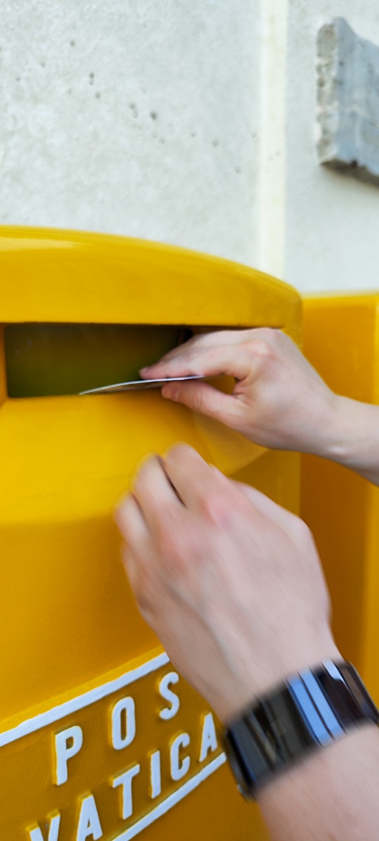 Андрей опускает открытку в почтовый ящик 