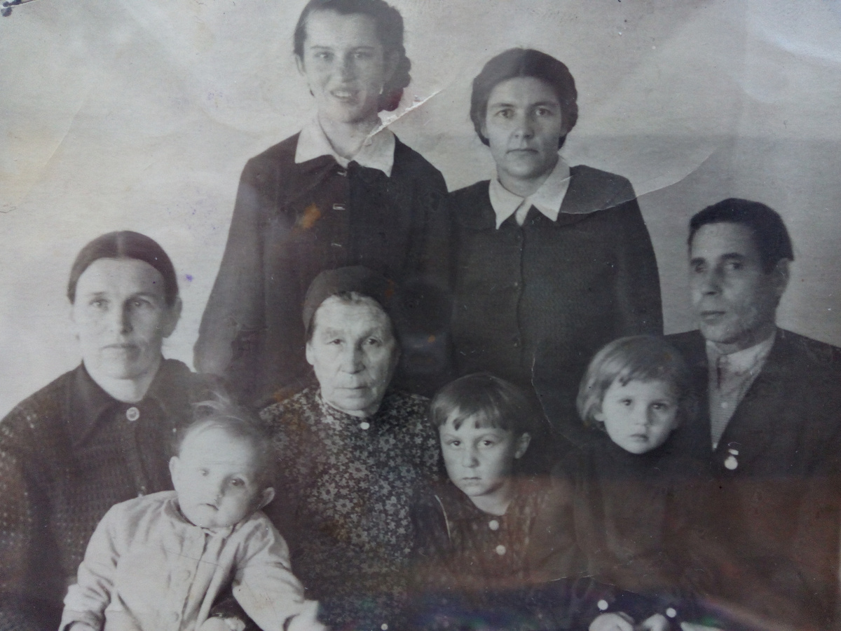 Мама слева с Томой сестрой на руках, я сижу на колене у отца. Бабушка, еще две сестры и тетя. 