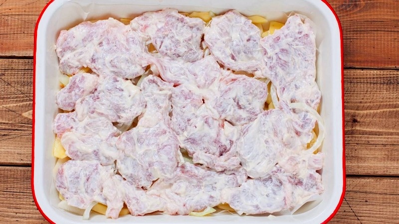 Укладываем слоями: картошку, лук, мясо, смазываем майонезом