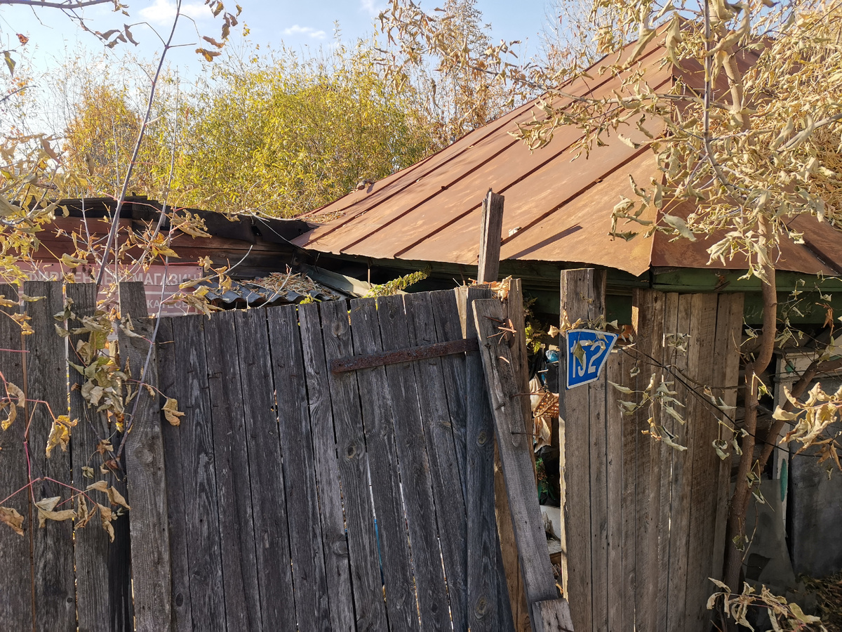 Калитка сорвана с петель и просто прислонена к забору.