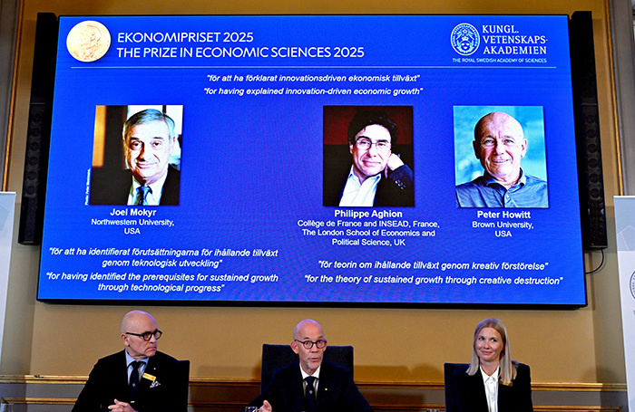    Джоэль Мокир, Филипп Агьон и Питер Ховитт (на экране слева направо).Anders Wiklund/TT News Agency/Reuters