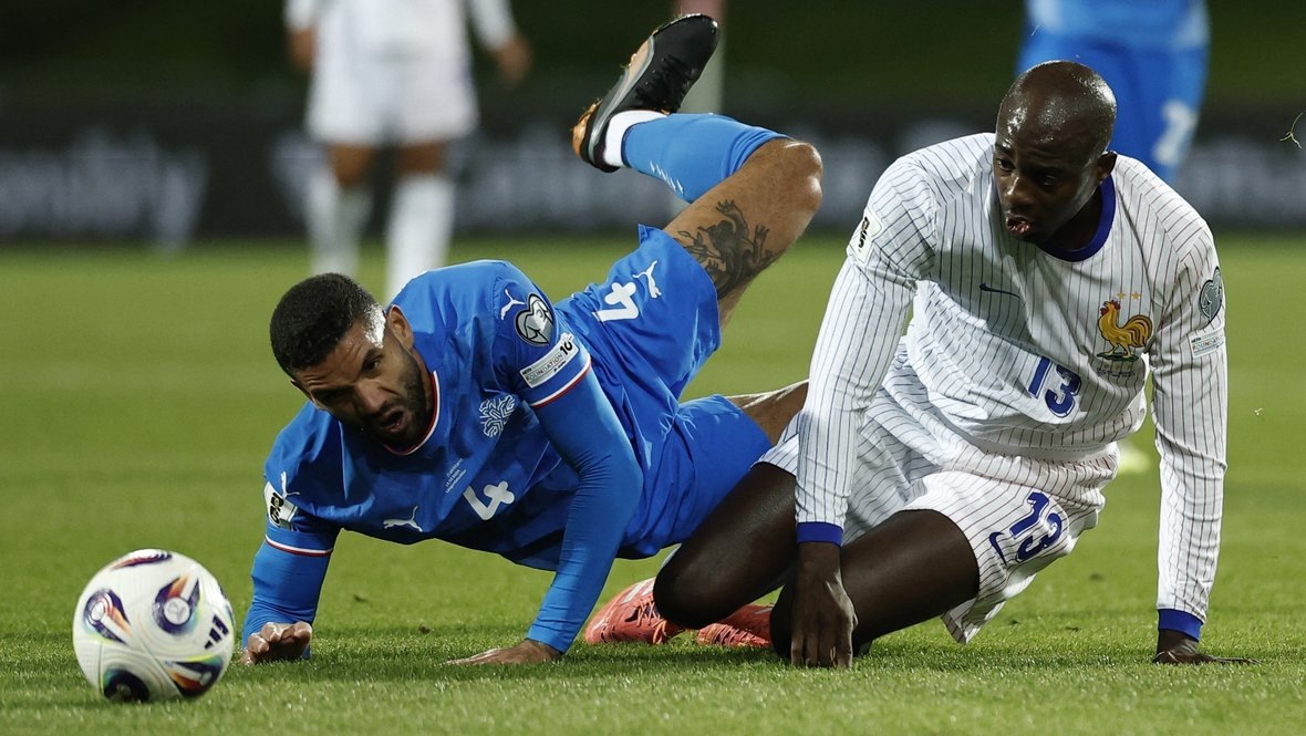    Защитник сборной Исландии Виктор Палссон и нападающий сборной Франции Жан-Филипп Матета в матче отбора ЧМ-2026 (2:2) 13 октября. Reuters