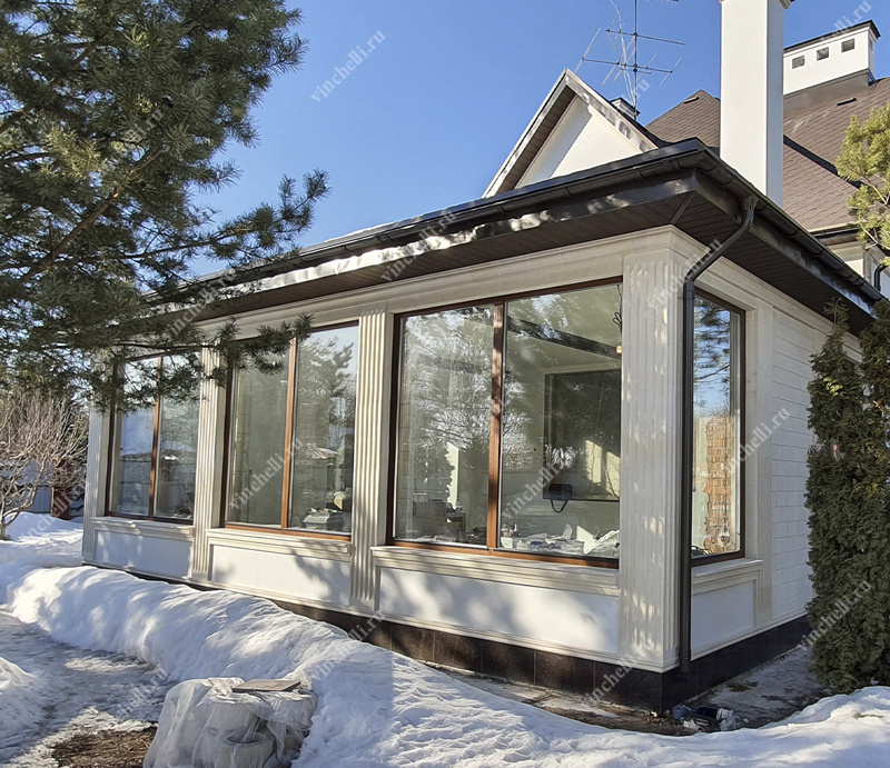 Пример эффективной теплоизоляции - деревянные окна большой площади гармонично вписаны в фасад, при этом надежно защищая дом от холода благодаря качественным материалам и продуманной конструкции.