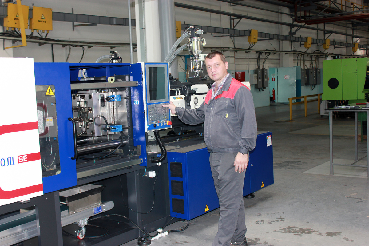 Алексей Архипов, механик цеха, проверяет работу нового термопластавтомата