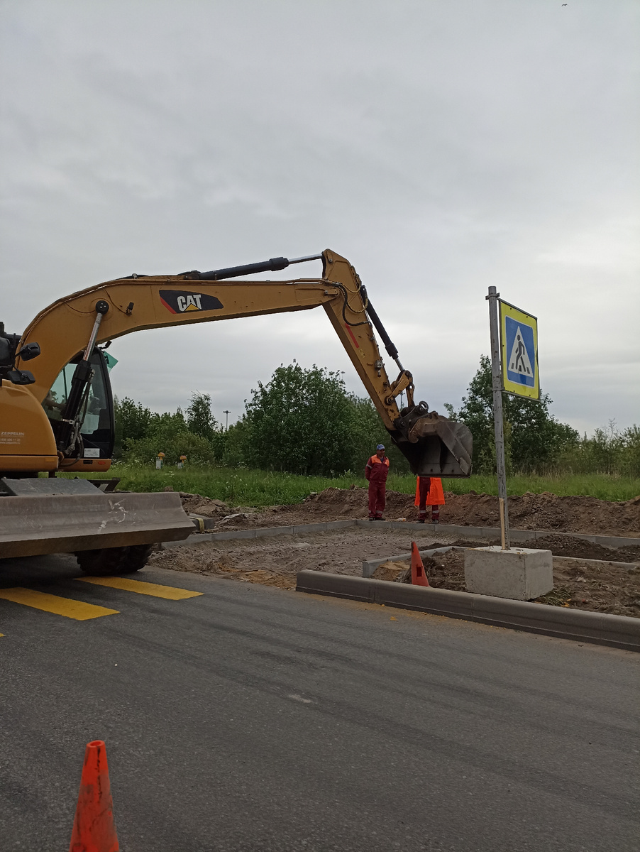 Грунтование и укладка щебня перед асфальтированием нового тротуара к надземному переходу в Бугры. 
