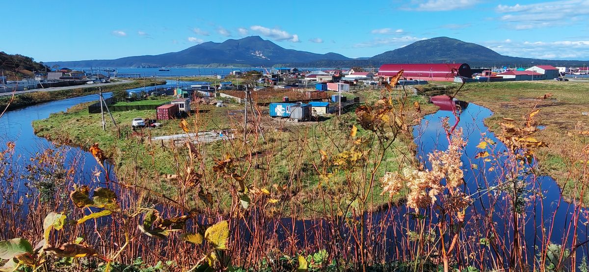 Излучина реки Серебрянки в Южно-Курильске. За полуостровком бухта Южно-Курильская и вулкан Менделеева