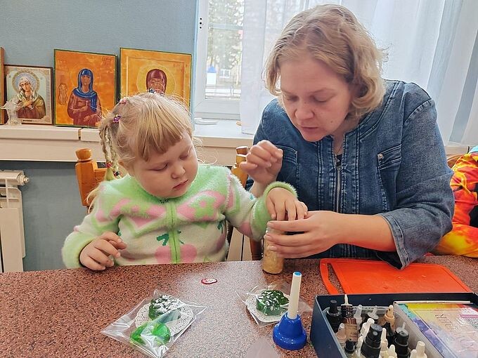 Девочка под руководством мамы добавляет поталь сверху на мыло