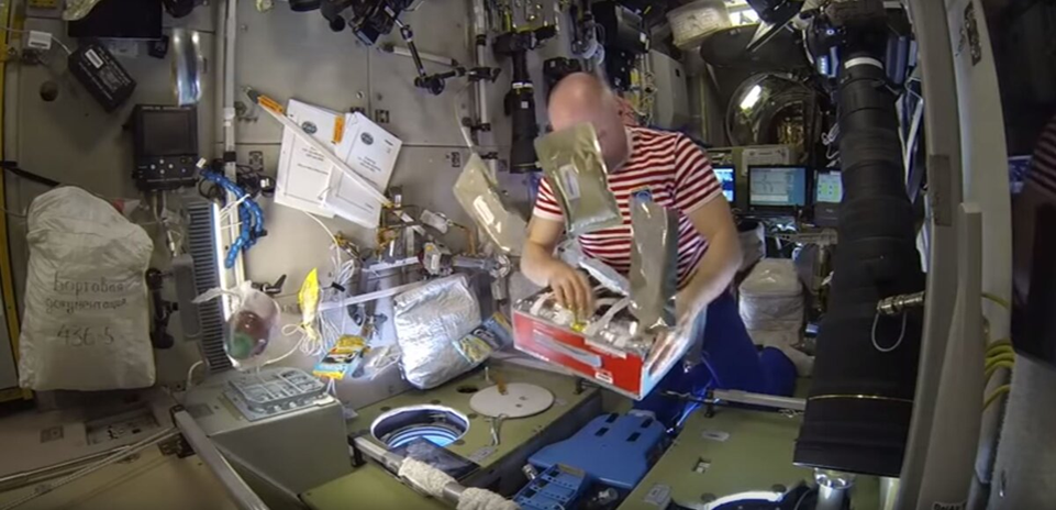 Космонавт разбирает продукты из рациона питания. Фото: Роскосмос