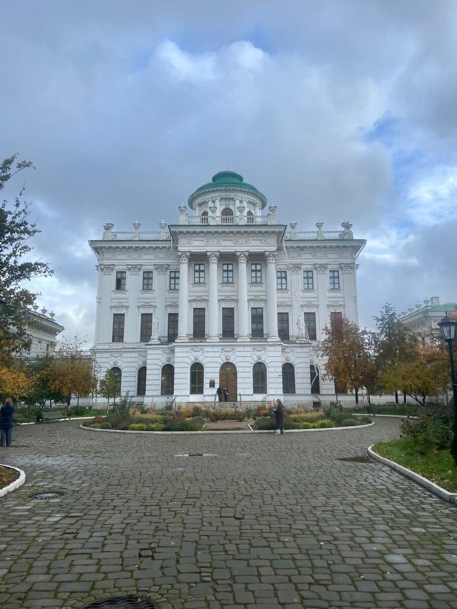 Дом Пашкова, вид с парадного въезда. Построен в 1786 году "водочным королем" Пашковым, после пожара 1812 г., сильно пострадало и было восстановлено в период 185-1818г.  Осипом Бове с некоторыми изменениями. Восстановил бельведер, заменив прежние коринфские круглые колонны на трёхчетвертные ионические, тем самым утяжелив дом постановкой более тяжёлого ордера над более лёгким. Кроме того, были видоизменены боковые продольные галереи. Первоначально они были открытыми переходными балконами и их венчали только балюстрады, сквозившие на фоне неба, теперь же они перекрыты двускатной кровлей. Здание наследники не использовали и постепенно оно приходило в упадок, в 1839 году после выкупа государством стало исключительно казенным зданием, позже в 1862г. стало публичным музейным зданием, в котором разместилась коллекция Румянцева. В 1988 году состояние здания стало критическим и начался ремонт, который длился до 2009г.