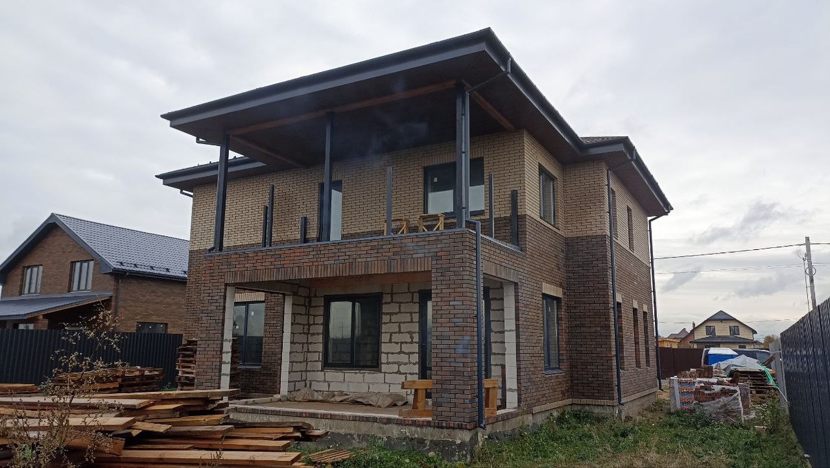 Дом из газобетона площадью 225 м² в Подмосковье. Фасад из керамического облицовочного кирпича выполнен с вентзазором — такое решение защищает стены от влаги и обеспечивает долговечность фасада. Фото с объекта «Интел Групп».