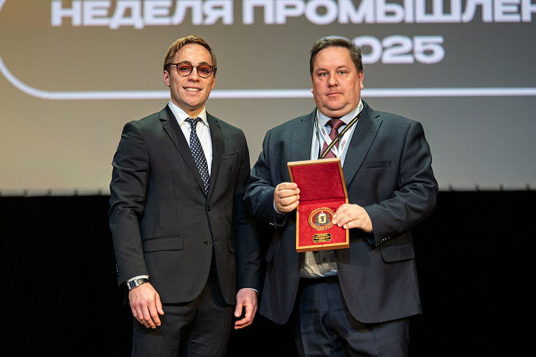 Денис Ануров получает награду из рук министра инвестиций и промышленности Александра Ольхова.