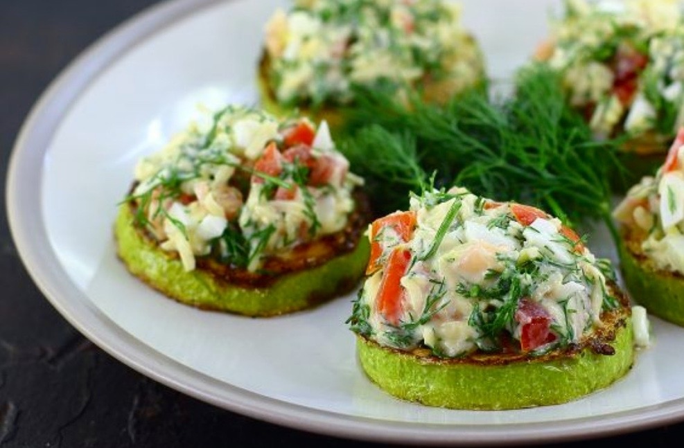 Обжаренные ломтики кабачка фаршированные треской и овощами.