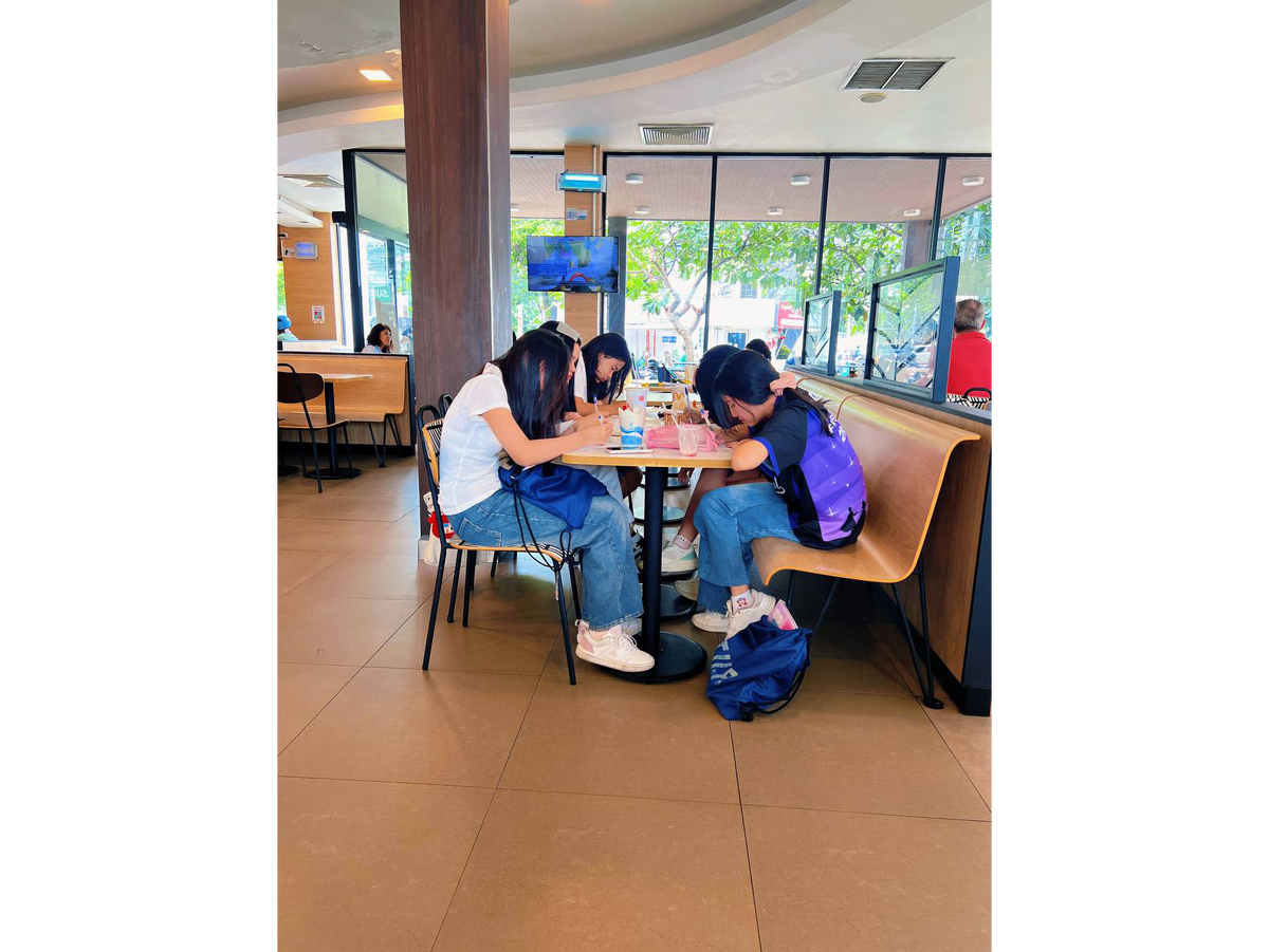 Тайские студенты сидят и решают задачи в одном из МакДоналдсов Бангкока