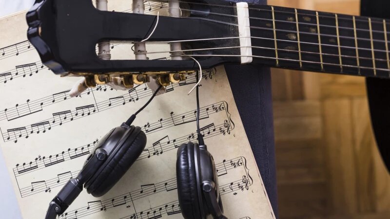     Наушники, ноты, гриф гитары. Фото: ru.freepik.com, автор freepik.