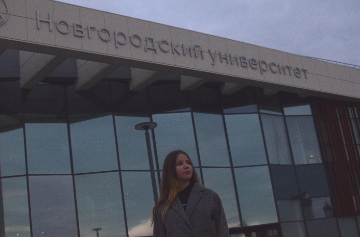 Даже специально сфотографировалась на фоне Новгородского университета