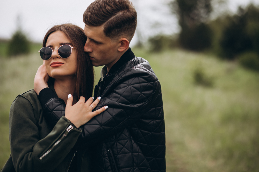Мужчина нежно обнимает женщину на природе, показывая заботу и близость — начало новых отношений после развода.