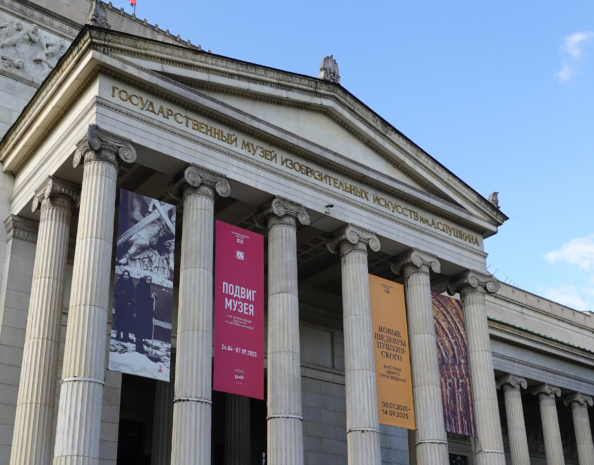 Желтая афиша выставки между колоннами