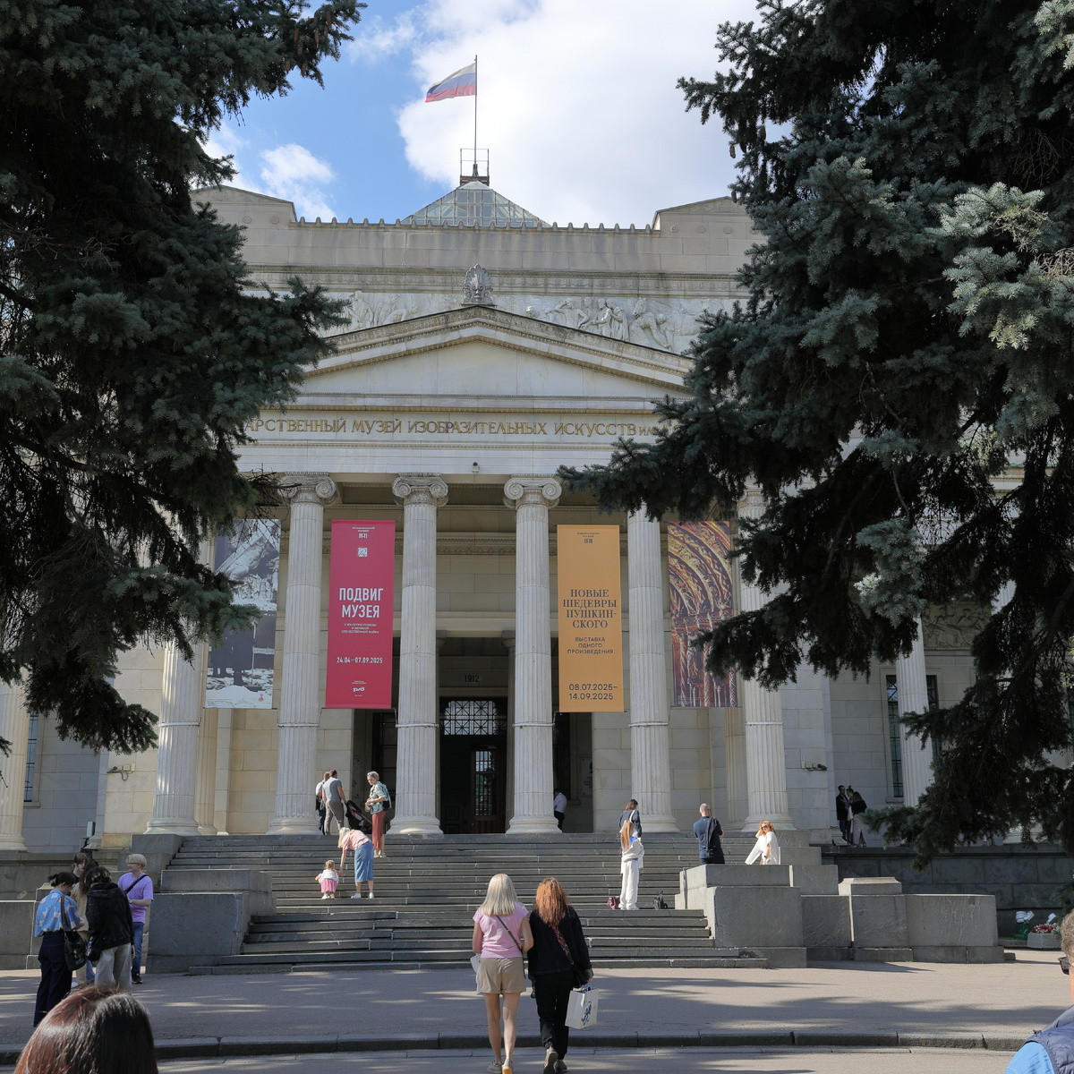 Желтая афиша выставки между колоннами