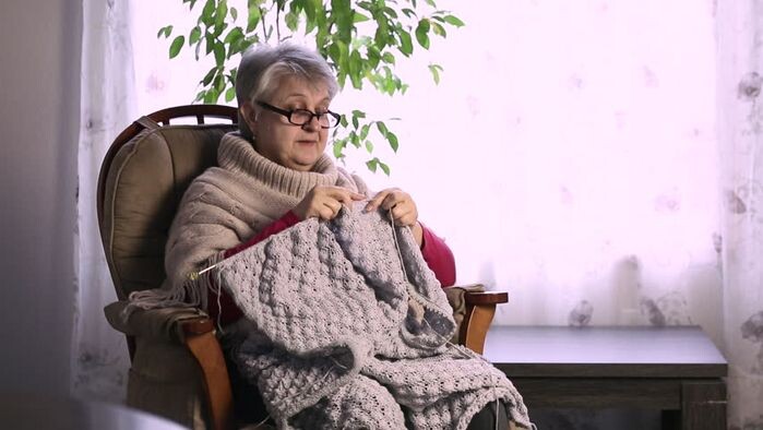 Женщина вяжет свитер