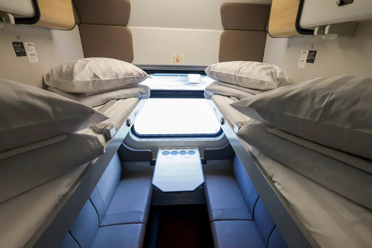 В нижние столики встроены беспроводные зарядки. У тех, кто едет наверху, столики индивидуальные, откидные. Источник: «Телеграмма-РЖД» / Telegram