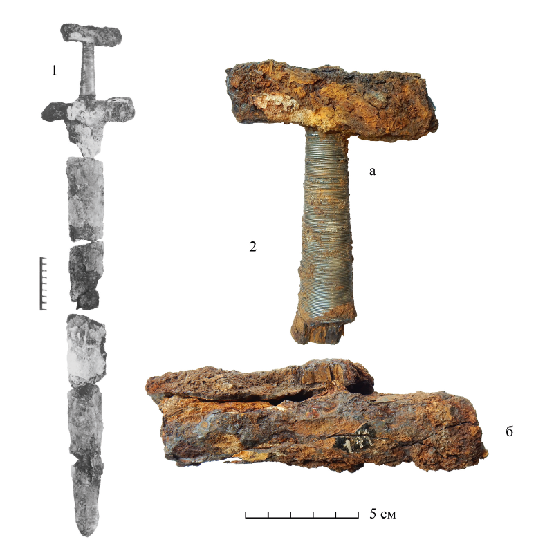 Меч из кургана Нюбиничи 10 до реставрации. 1 – общий вид на момент находки ,  2 – фрагменты рукояти в состоянии на 2020 год: а – основание навершия с рукоятью, б – перекрестие