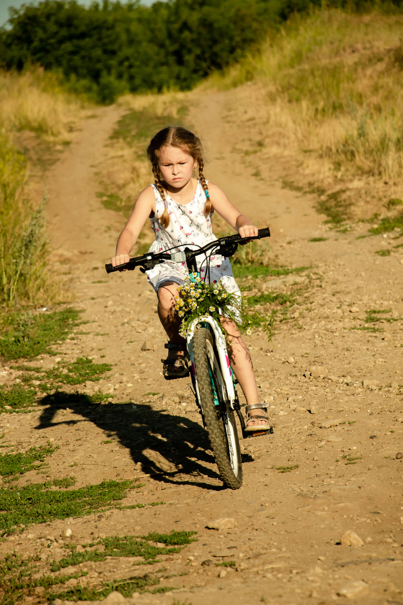 Девочка едет на велосипеде с горки. Выдержка 1/1000