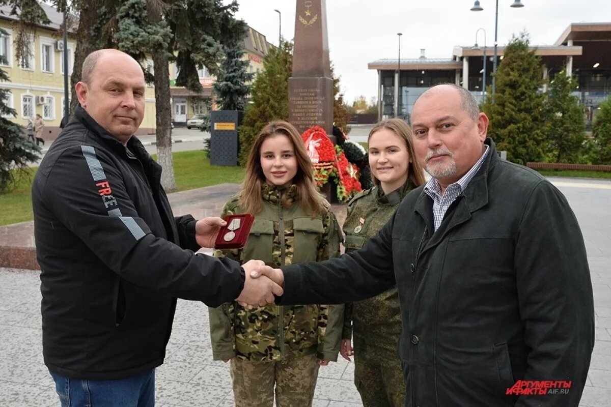    Руководитель отряда поисковиков Александр Орлов (справа) вручил медаль деда «За отвагу» Владимиру Султанову.