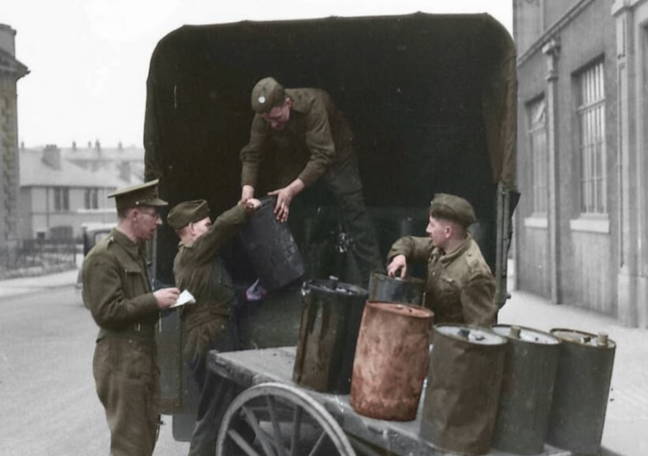 Британские солдаты загружают грузовик бочками с отработанным маслом для транспортировки на пункт приема