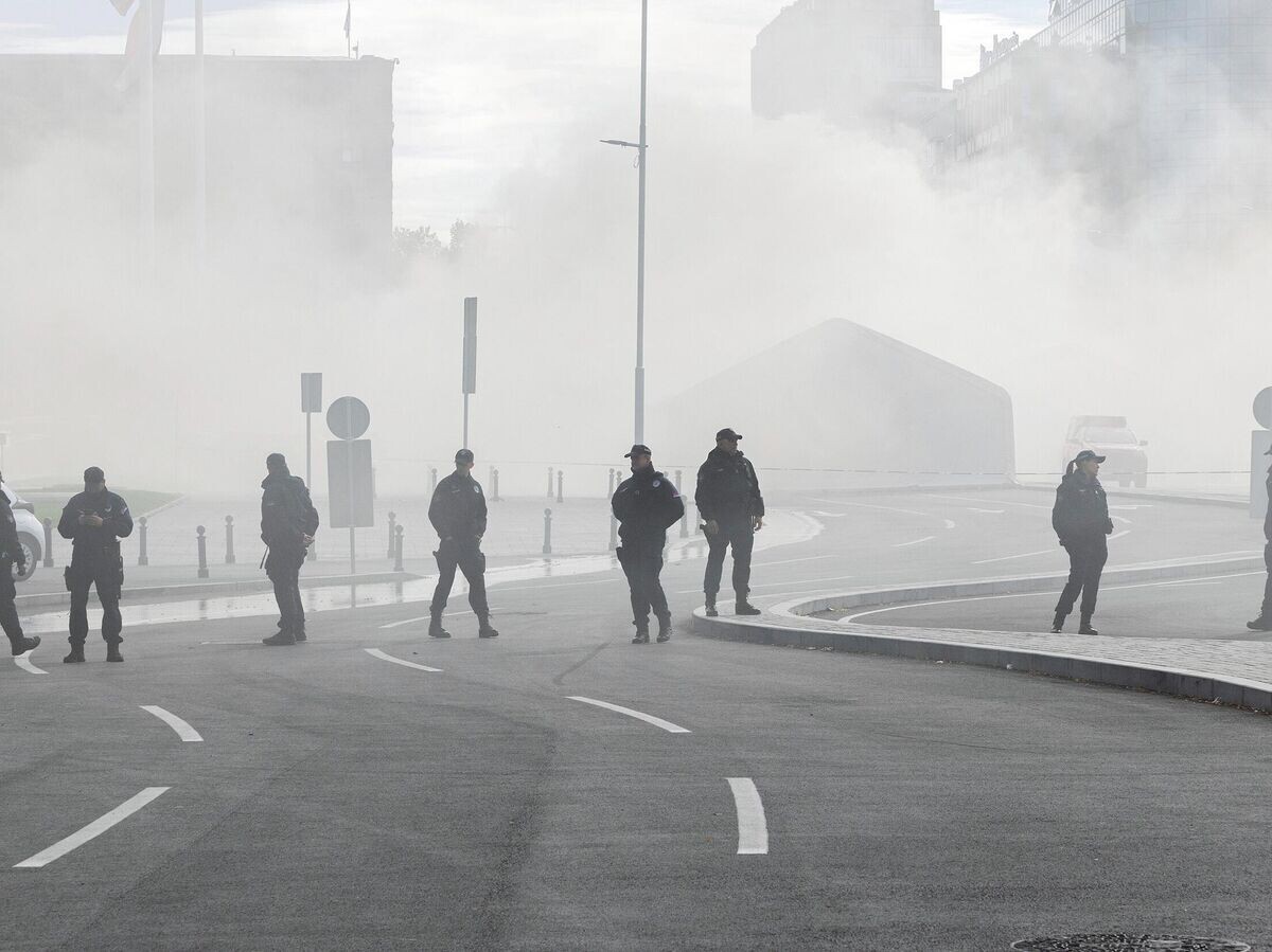    Полицейские во время локализации пожара в лагере сторонников правительства возле здания сербского парламента в Белграде© AP Photo / Marko Drobnjakovic
