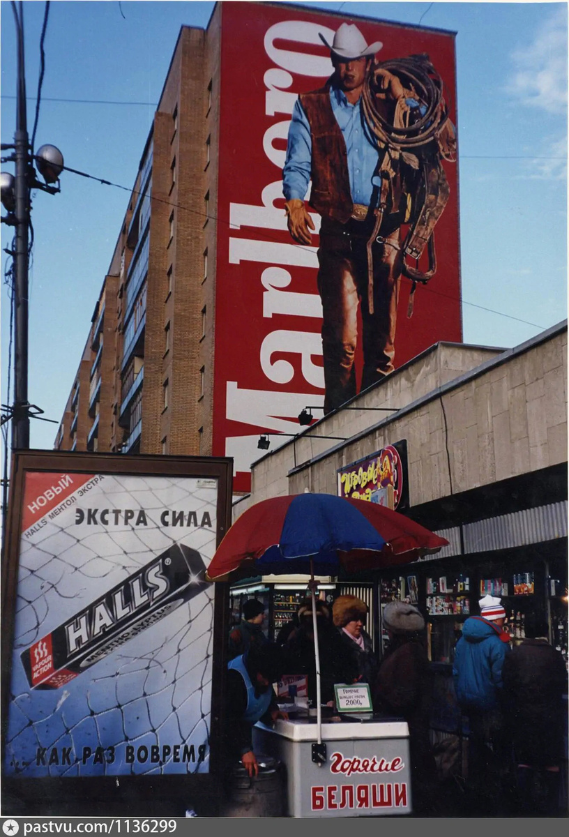 Ковбой "Mallboro" преследовал москвичей буквально повсюду: на остановках, на стенах зданий и т.п. Это Большая Дорогомиловская улица. Из интересного здесь есть реклама конфет "Halls". Рядом с беляшами. Возможно, не просто так, 1995-1996. Автор фото: В.Т. Стигнеев. С сайта www.pastvu.com.