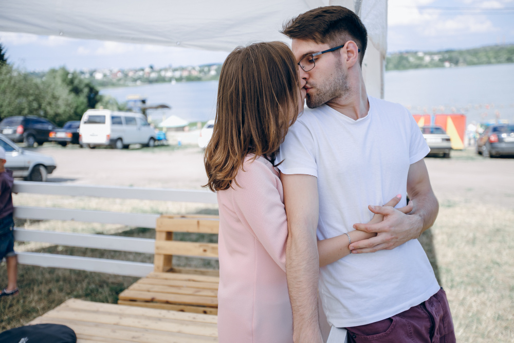 Пара обнимается и целуется на улице — лёгкий флирт и проявление симпатии между мужчиной и женщиной.