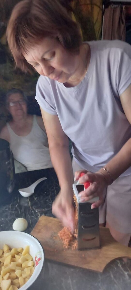 Социальный работник шоркает морковку на тёрке