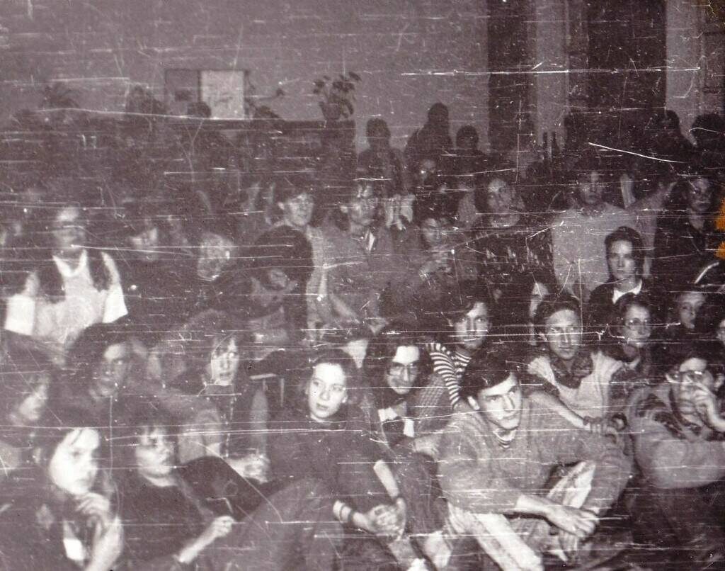 Автор фото не установлен. Зрители на концерте Янки в Иркутске, март 1989г. В центре (чуть выше и левее физического центра фото молодой человек с бородой наклонился вперед, за ним правее Т. Блажко) Татьяна Блажко, неустановленный зритель, еще правее Я, у меня пальцы рук сцеплены "в замок", и мой однокурсник Слава Орсоев.