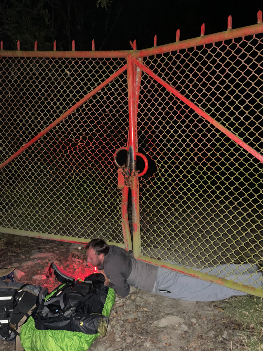 Ваня пролезает под забором на входе в парк