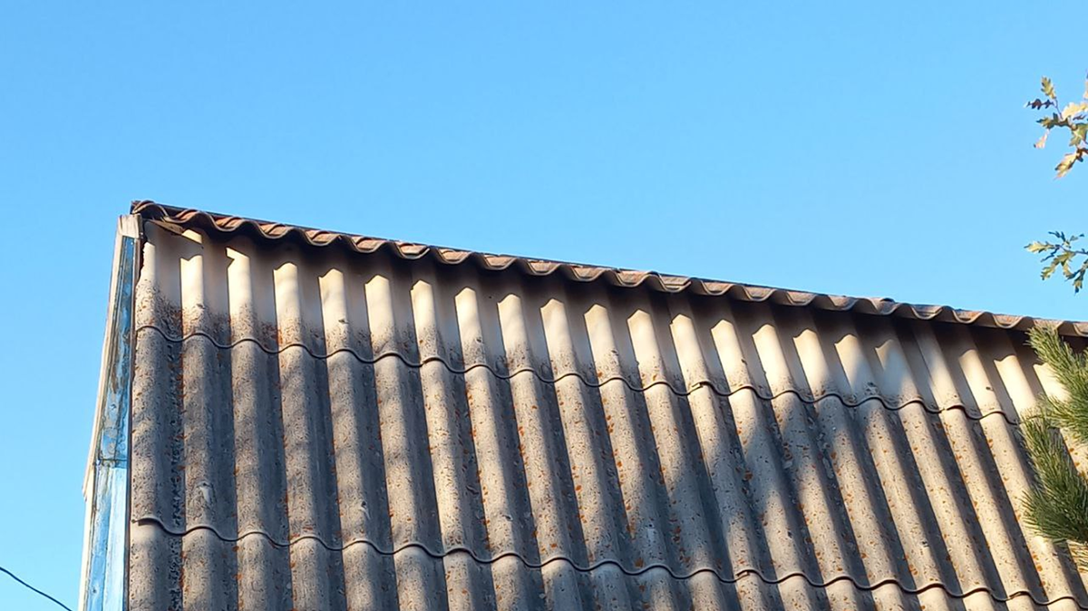 На фото: шифер с годами обрастает мхом, начинает крошиться и протекать.