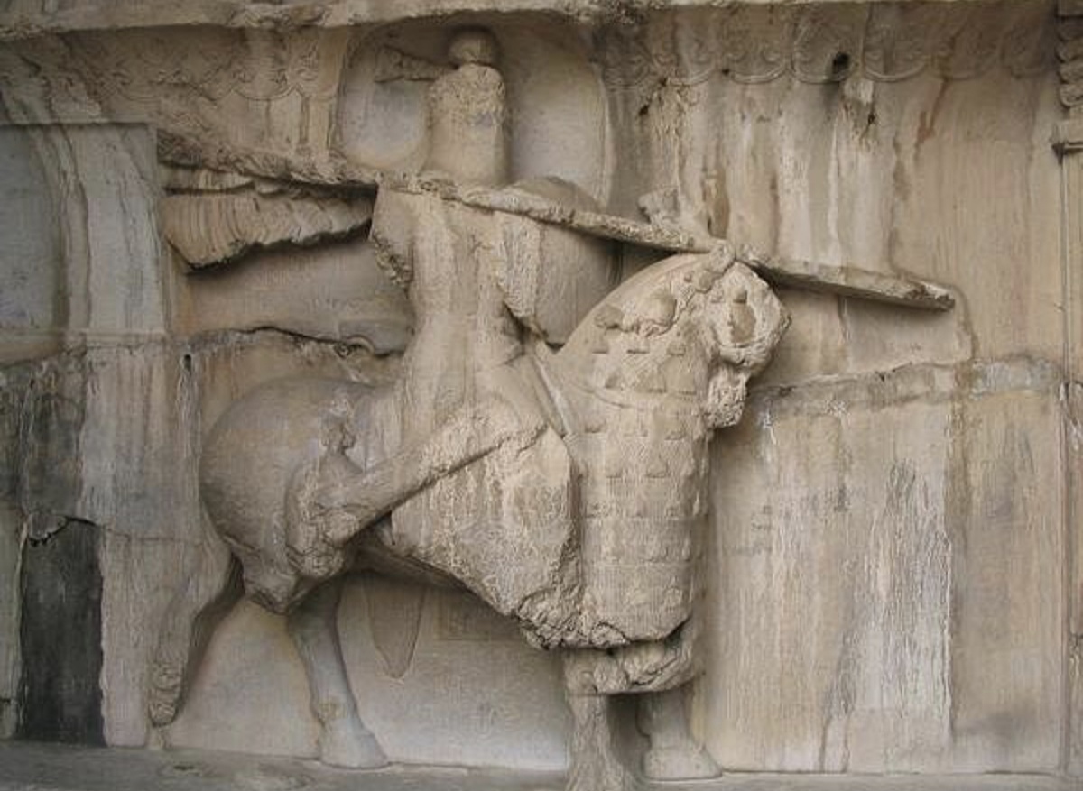 Рельеф из Тaq-e Bostan (Иран), времён Сасанидов. Показывает всадника полностью в броне с защищённым конем. 