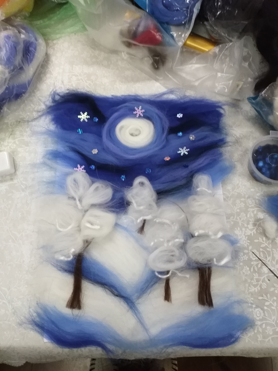 В качестве подложки взять белую ббелую бумагу, затем подложку из клеевого флизелина клеем вверх, потом выложить слой белой шерсти, а затем уже сам сюжет. 