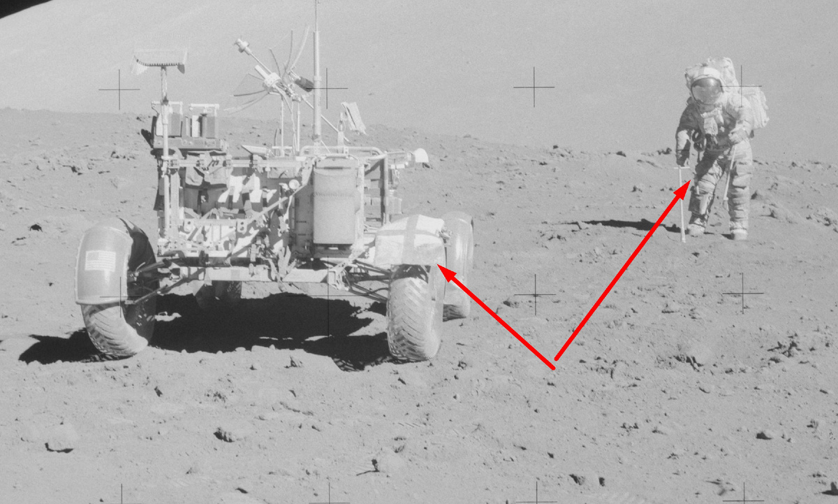 AS17-143-21836 Якобы астронавт якобы на Луне около якобы лунного ровера. Стрелками указан молоток, торчащий из кармана и оторванная часть крыла, которая была якобы "случайно" оторвана.