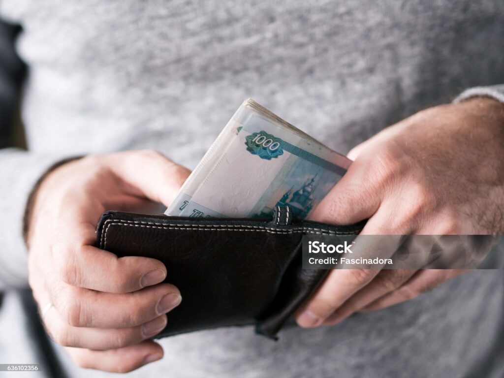    Hands take out russian rubles from wallet. Closeup on a man's hands as he is getting a banknote out of his wallet Редакция газеты