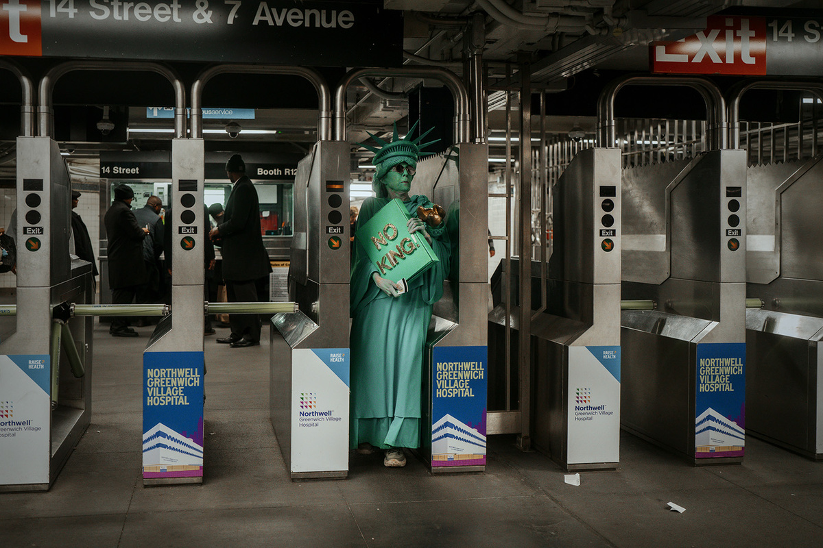   Olga Fedorova / AP- Женщина в костюме статуи Свободы заходит в метро после акции протеста «Без королей» в Нью-Йорке