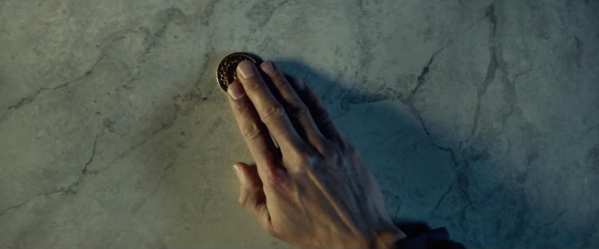 Кадр из фильма “Джон Уик”. Здесь под рукой лежит золотая монета, валюта теневого мира. «Неофициальная» валюта сама по себе должна злить власть имущих, а если ещё и чеканится из драгоценного металла, добыча и распространение которого жёстко регламентируются законом, выявление её источника станет главнейшей задачей правоохранительных органов! Фактически только из-за таких вот монеток теневой мир убийц быстро прекратил бы существование; а само избавление от незаконного формирования киллеров стало бы лишь сопутствующей задачей.