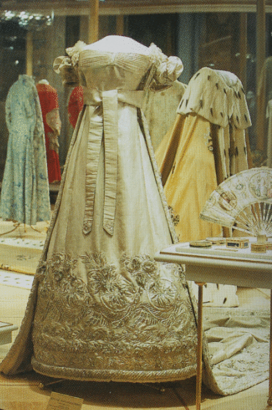 Платье выполнено в переходном стиле от ампира к историзму.